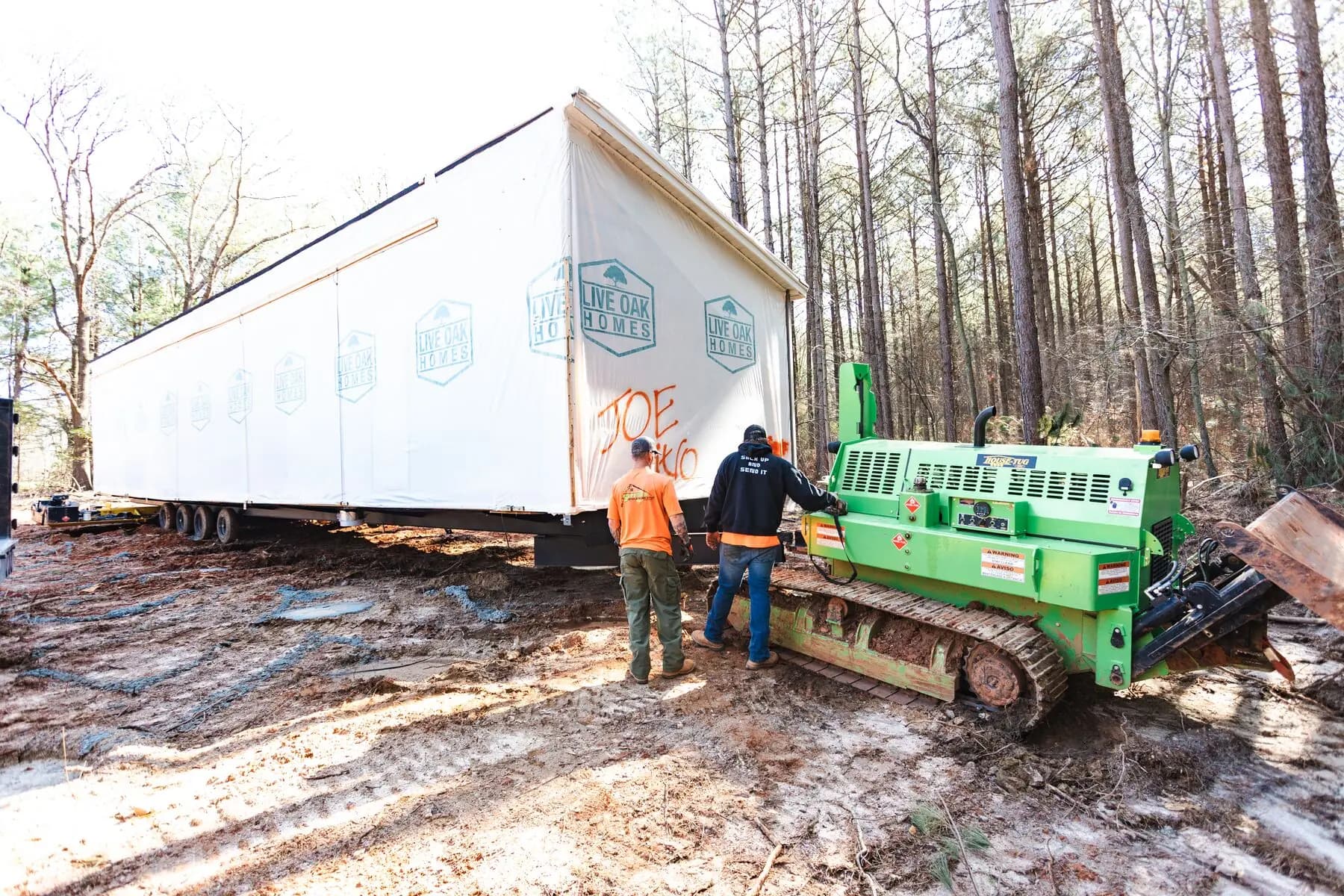House tug positioning home at site.