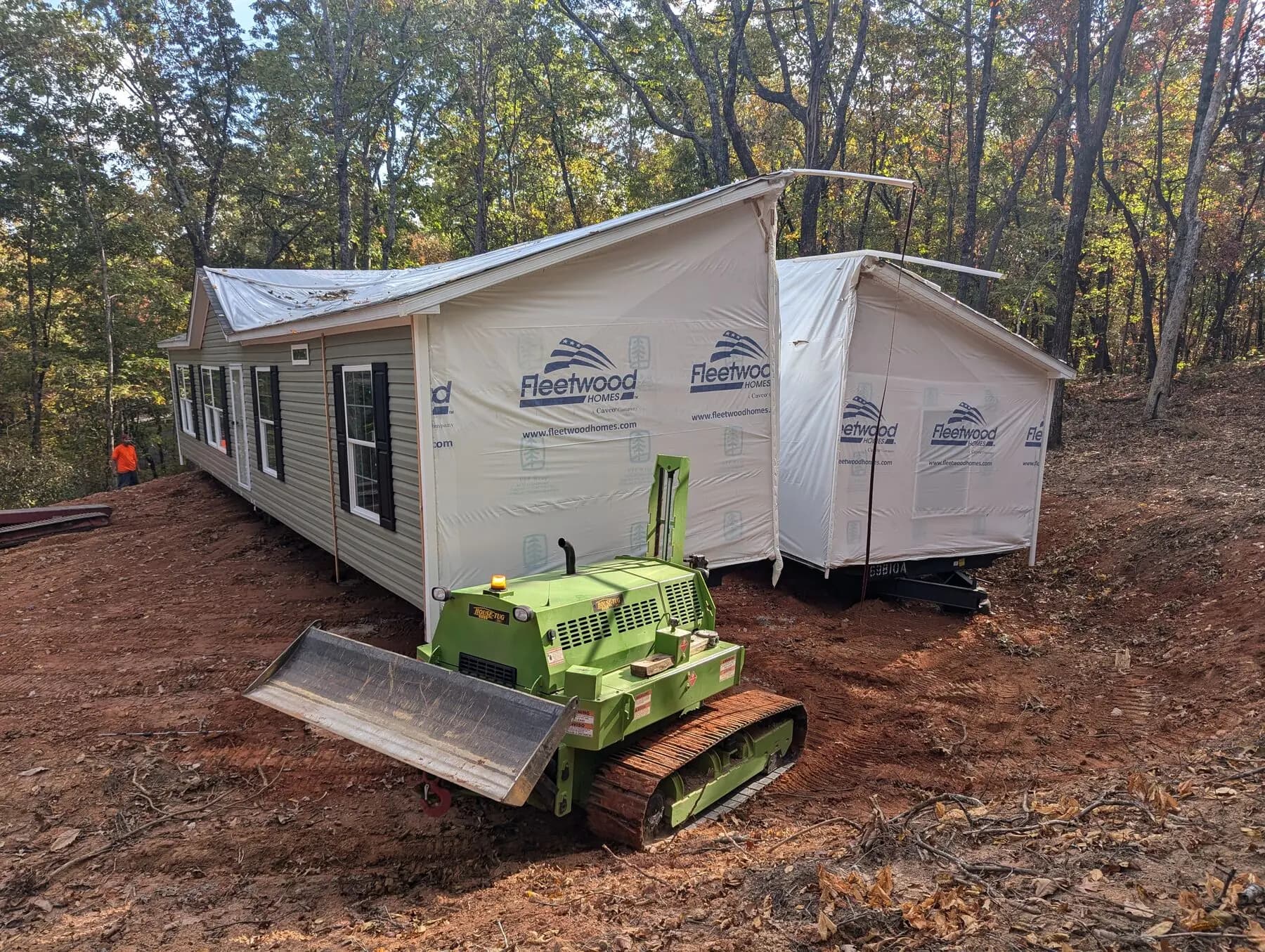 House tug positioning home in forest.