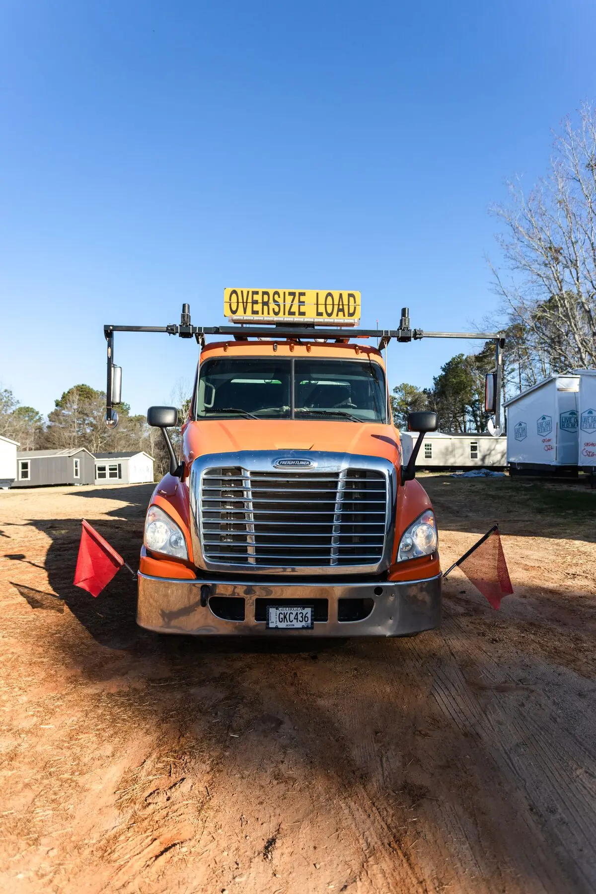 Orange oversize load truck front.