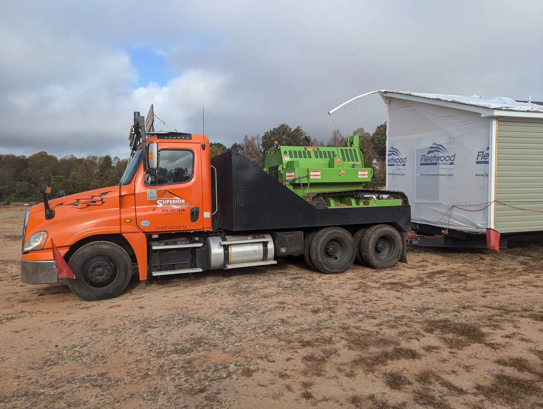Orange transport truck beside home.