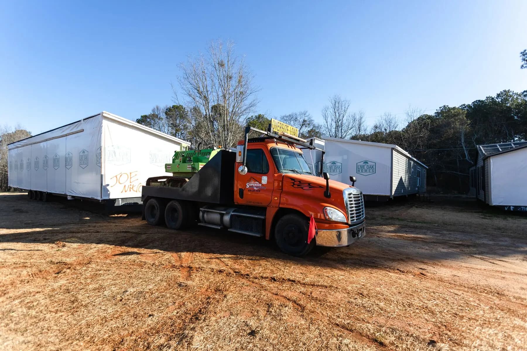 Orange transport truck dealer yard.