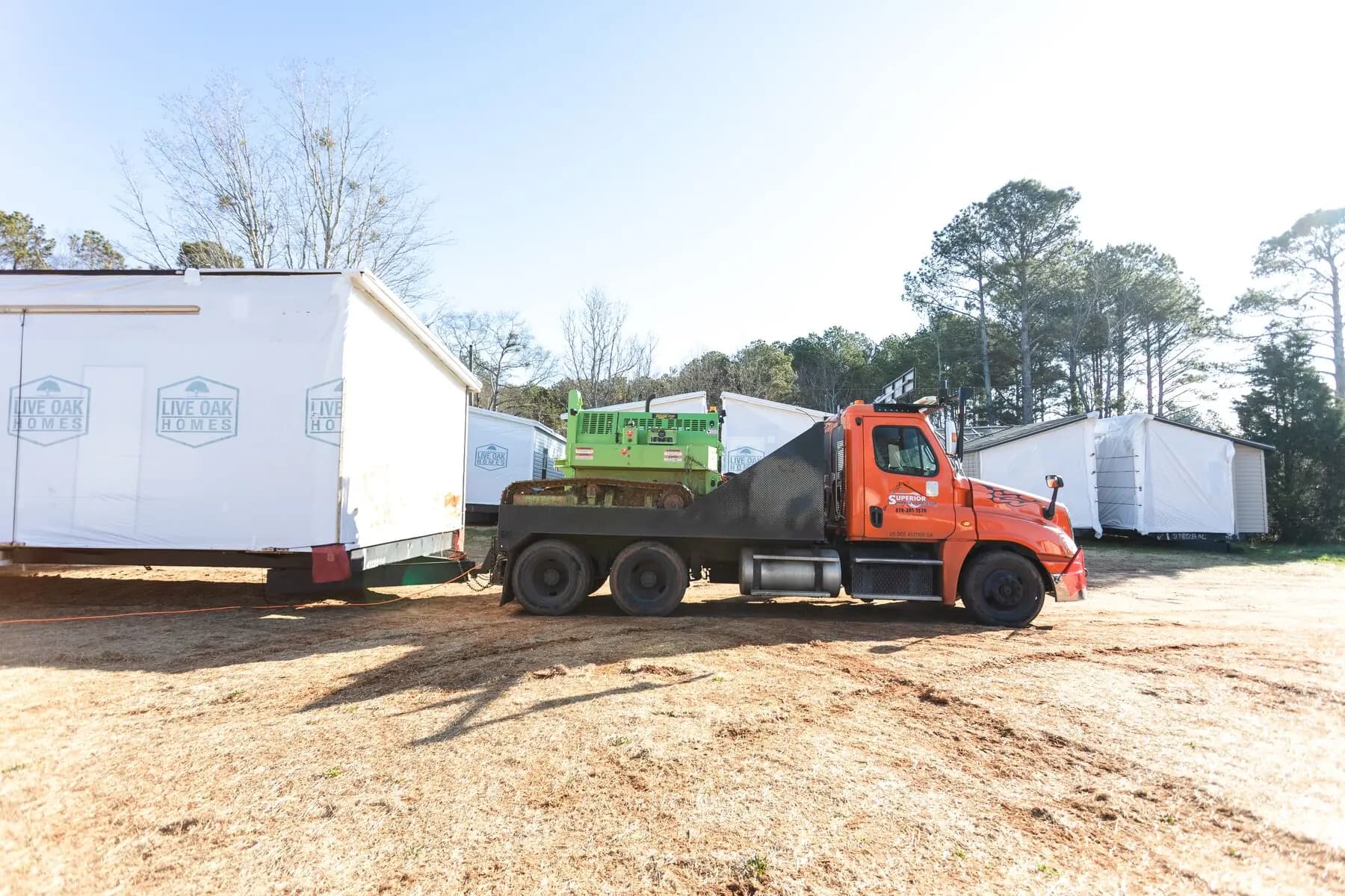 Orange truck carrying house tug.