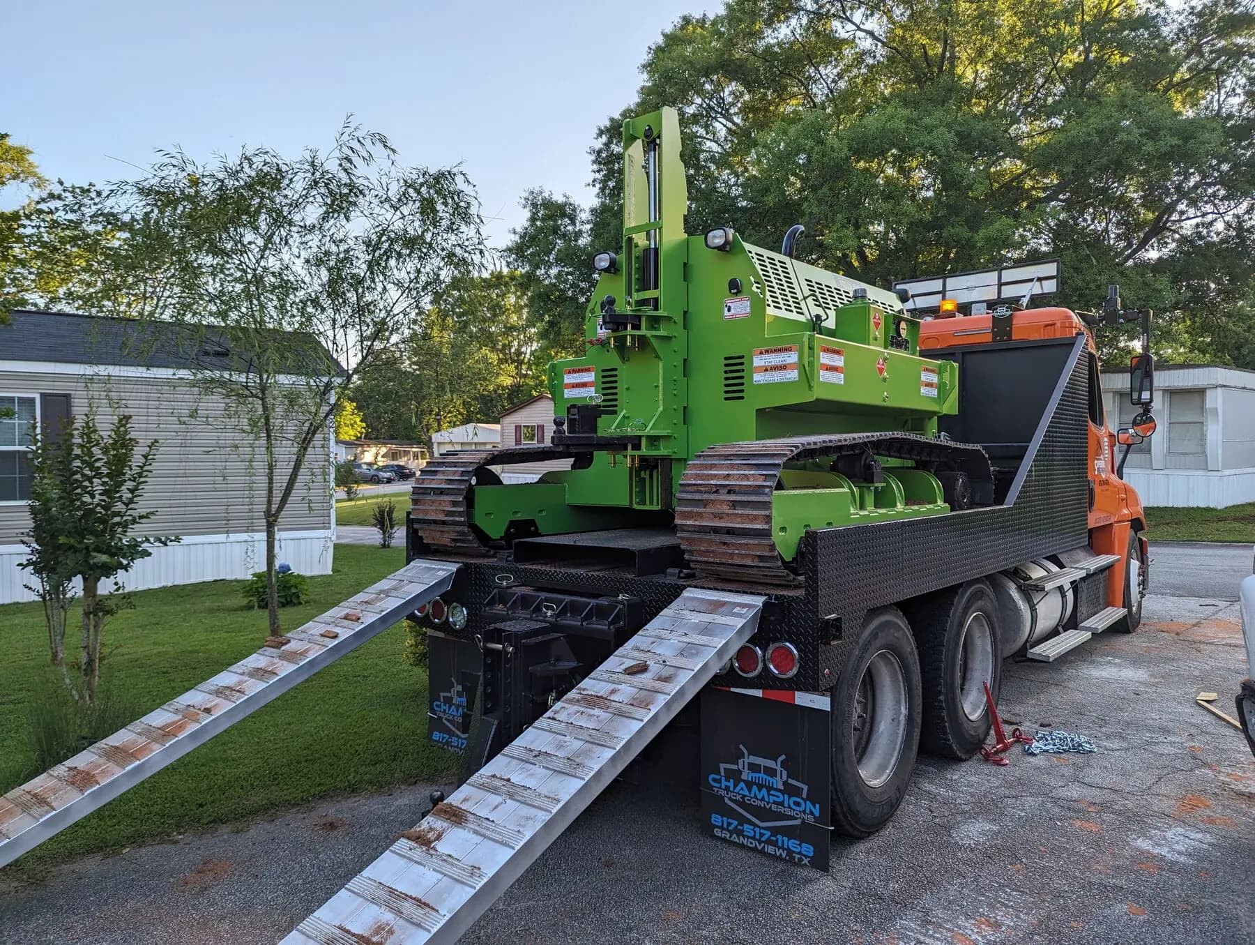 Tracked house tug loading onto transport truck.